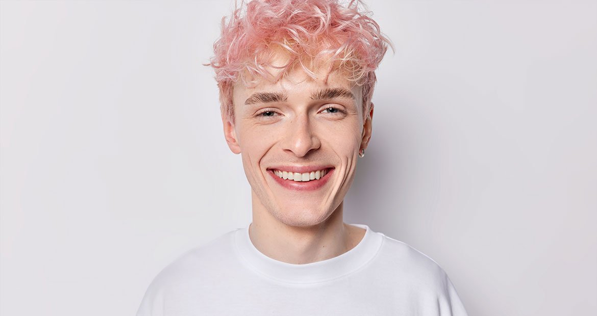 homem branco com cabelo curto pintado de rosa